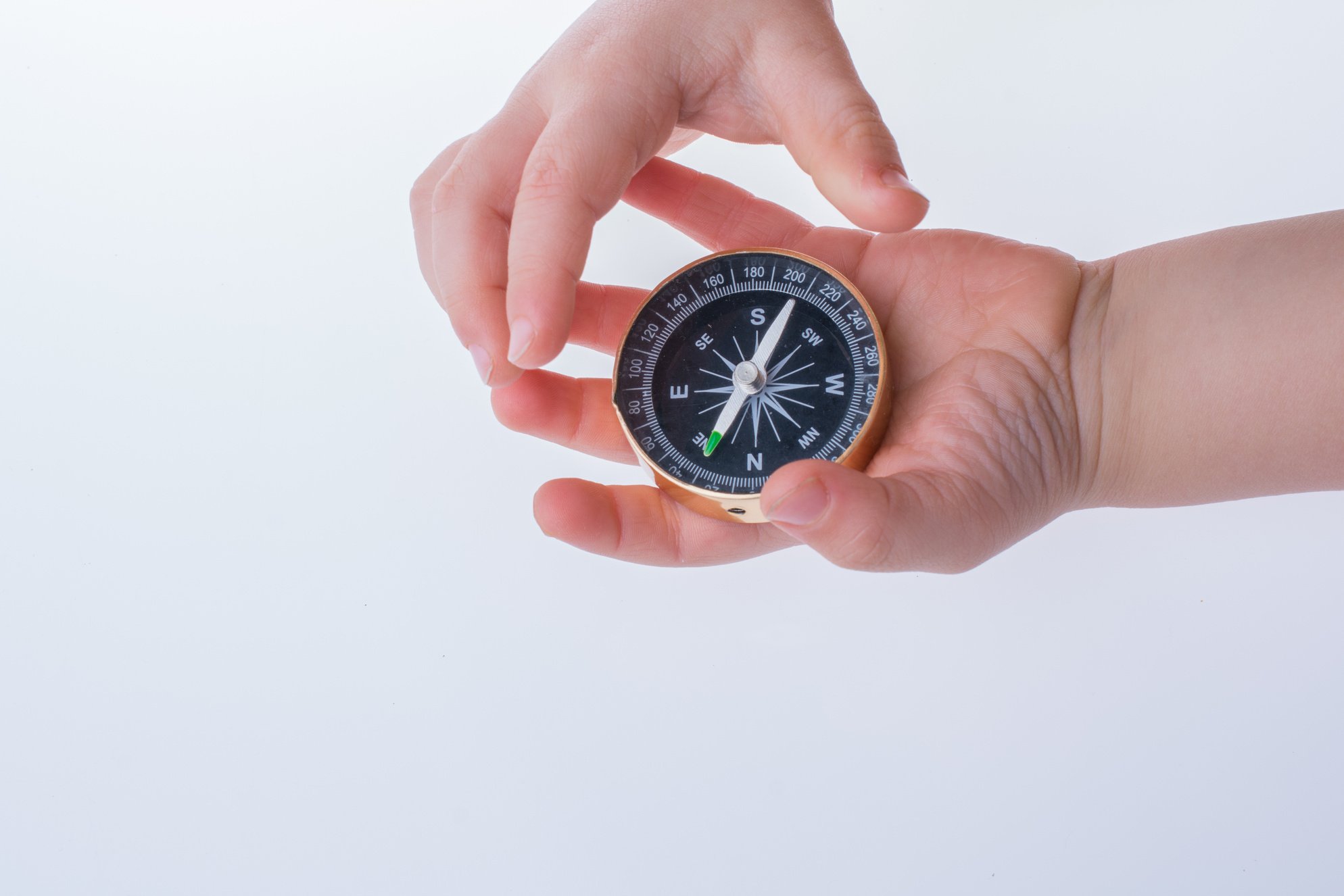 Hand holding a compass  on white background